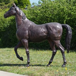 Bronzefigur "Pferd im Schritt" auf einer Wiese